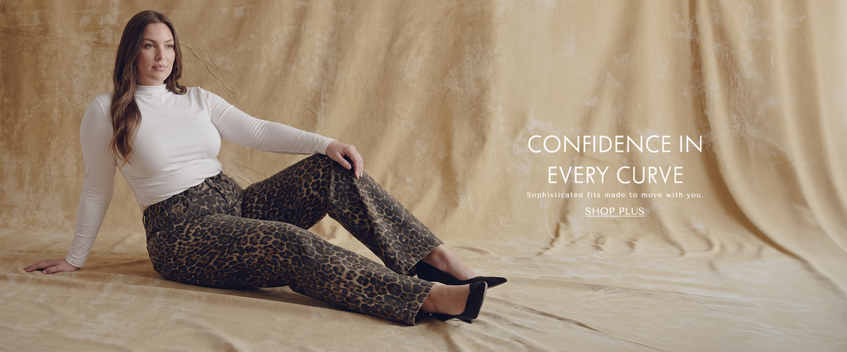 A plus size model wearing long sleeve white shirt and cheetah print jeans with text 'confidence in every curve. Sophisticated fits made to move with you. CTA reading SHOP PLUS'