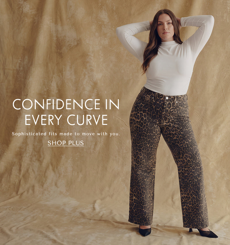 A plus size model wearing long sleeve white shirt and cheetah print jeans with text 'confidence in every curve. Sophisticated fits made to move with you. CTA reading SHOP PLUS'